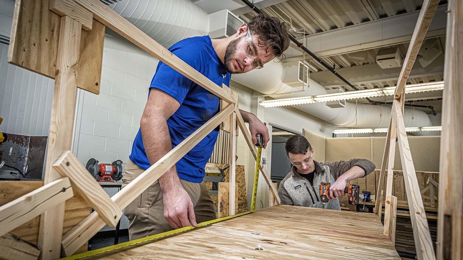 Civil engineering students building model of a bridge